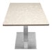 A white Art Marble Furniture quartz table top on a metal table base.