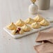 A tray of Rich's raspberry-filled shortbread cookies with a cut open cookie on it.