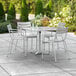 A Lancaster Table & Seating silver aluminum dining table with chairs on an outdoor patio.