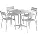 A white Lancaster Table & Seating outdoor dining table with 4 white chairs.