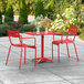 A red table and chairs on a patio.