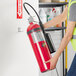 A person holding a Buckeye carbon dioxide fire extinguisher.