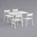 A white Lancaster Table & Seating outdoor table and four chairs.