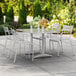 A white table and chairs on a patio with a glass on the table.