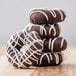 A stack of Rich's chocolate cake donuts with white frosting.