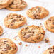 A group of Christie Cookie Co. prebaked chocolate chunk cookies on a white surface.