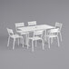 A white Lancaster Table & Seating dining table and chairs set with an umbrella hole.