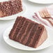 A slice of Rich's chocolate cake on a plate with a fork.