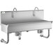 A Regency stainless steel utility sink with 2 knee-operated faucets.