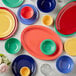 A yellow Acopa Foundations melamine plate on a table with a green bowl and a red plate.