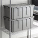A stack of Lavex gray plastic flip-lid totes.