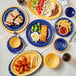 A yellow bowl on a table with plates of food.