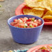 An Acopa purple melamine bouillon cup filled with salsa on a table.