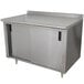 A stainless steel Advance Tabco work table with cabinet base and mid shelf.