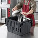 A man putting a lid on a Lavex black industrial tote.