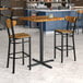 A Lancaster Table & Seating vintage butcher block bar table with two chairs.