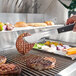 A person using a knife to cut meat on a Crown Verity built-in grill counter.