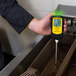 A hand holding a Vito Fryfilter FT 440 with a temperature gauge screen.
