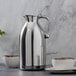 An Alfi stainless steel vacuum insulated carafe on a marble counter.