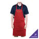 A man wearing a red Chef Revival bib apron with a custom embroidered logo on the front.