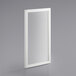 An Avantco white rectangular mirror on a grey surface.