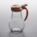 a glass pitcher with a red handle