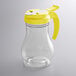 a clear glass vase with a yellow lid