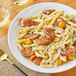 A plate of pasta with Warrington Farm Meats Hot Italian Sausage links and parmesan cheese.