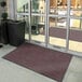 A red Lavex Plush Dilour doormat outside of a building.