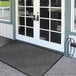 A Lavex gray chevron entrance mat at the front of a building.