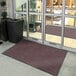 A red Lavex Plush Dilour entrance mat with a black and brown pattern.