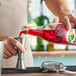 A bartender pouring Rose's grenadine into a glass.