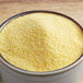 A wooden bowl filled with yellow medium grain polenta.