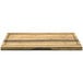 A Front of the House Reversible Crushed Bamboo Serving Board with hand grips on a wooden surface.