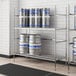 A Regency metal shelf with kegs on it.