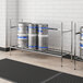 A Regency metal shelf rack with three kegs on it.