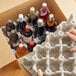A person holding a Lavex Molded Fiber upright wine shipper box with a tray of wine bottles inside.