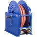 A blue Coxreels spring rewind hose reel with a low pressure hose attached.