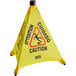 A yellow triangular Lavex Caution Wet Floor sign with black text in a wall-mounted case.
