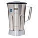 A stainless steel Waring blender jar with a black lid.