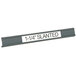 A gray slanted plastic label holder on a metal shelf with a white label.