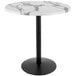 A round white marble table with a black round base.