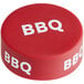 A red "BBQ" silicone lid with white text on a table.