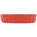 A red fluted quiche dish with a white background.