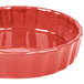 A red fluted china quiche dish with a rim.