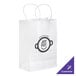 A white paper shopping bag with handles and a logo on it.