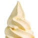 A close up of a white ice cream cone with a swirl of soft serve.