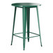 A Lancaster Table & Seating emerald green metal bar height table with a round top.