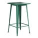 A Lancaster Table & Seating emerald green metal table with legs.