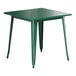 A green metal table with white legs.